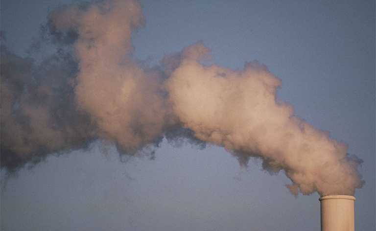 Air pollution smoke rising from a plant tower