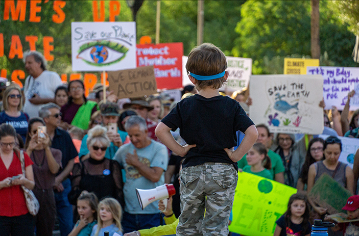 Young boy stands before climate marchers (Jake Meyers/University of Arizona).