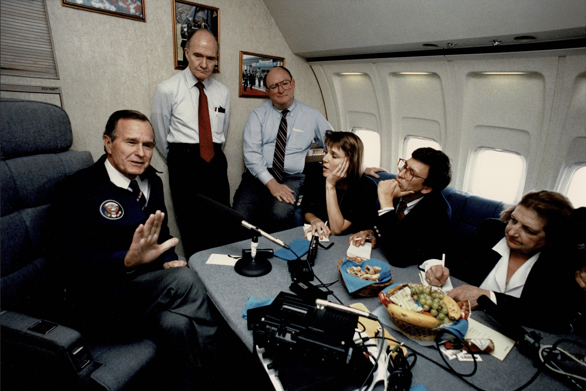 Frank Sesno, second from right, sits with other press, including White House press corps icon Helen Thomas (far right), interviewing then-President George H.W. Bush aboard Air Force One on May 13, 1989. 
