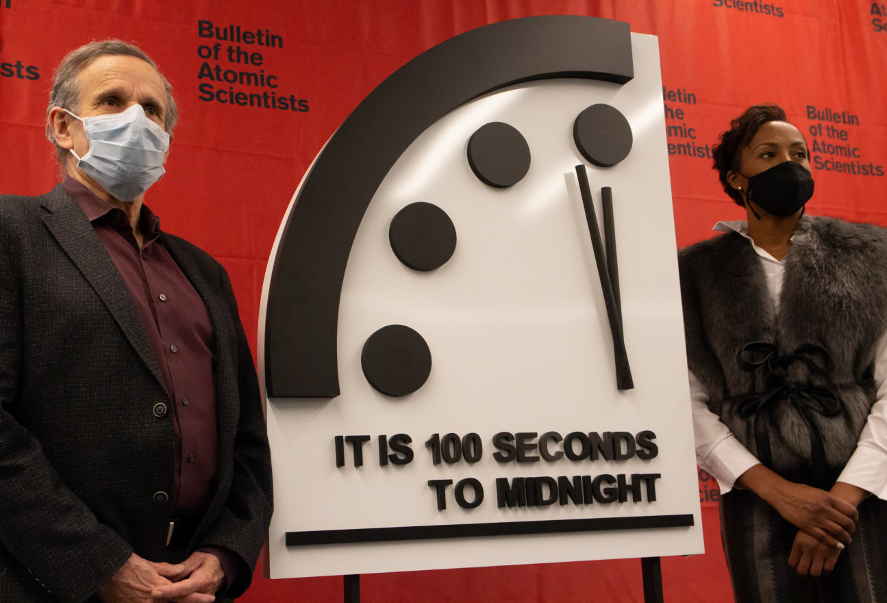 Robert Rosner and Suzet McKinney stand on either side of the Doomsday Clock, which reads "It is 100 seconds to midnight."