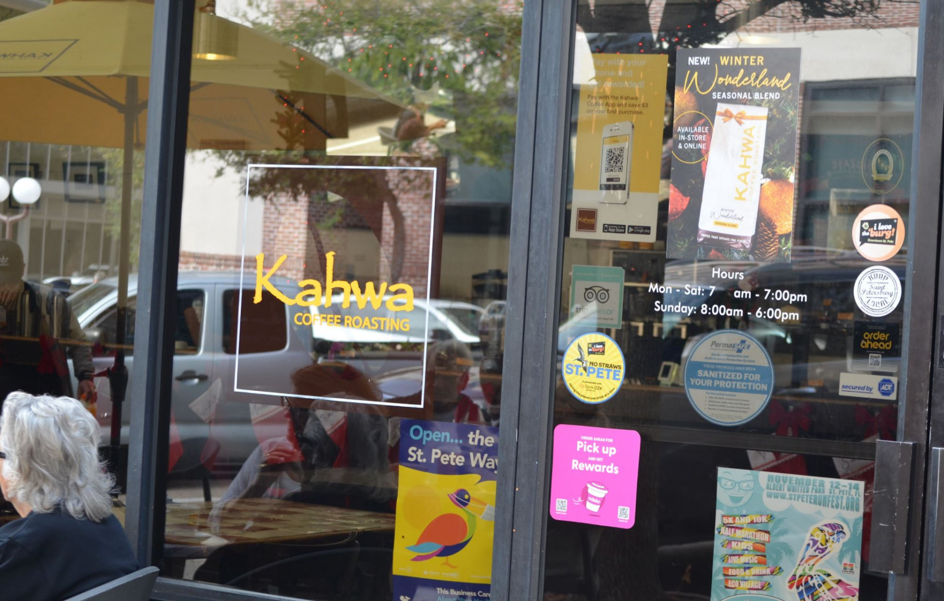A yellow "No Straws St. Pete" sticker appears on the glass door of Kahwa Coffee Roasting.