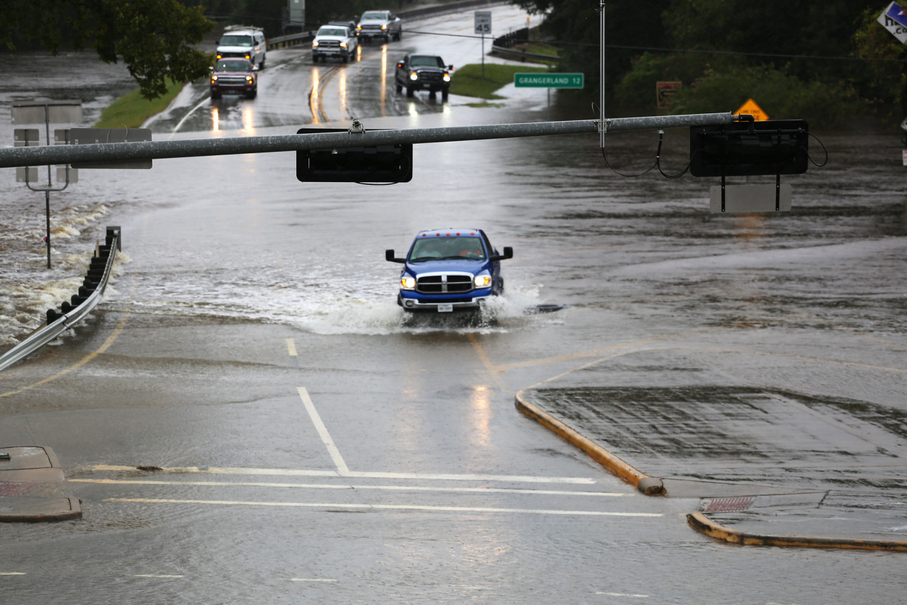 A pick-up truck drives through a flooded intersection during the aftermath of Hurricane Harvey. 