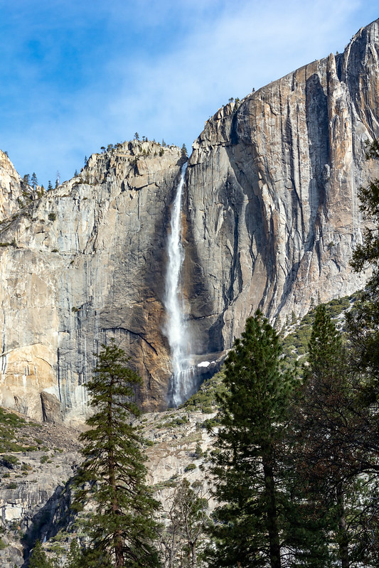 A waterfall pours down a high cliff in Yosemite National Park. 