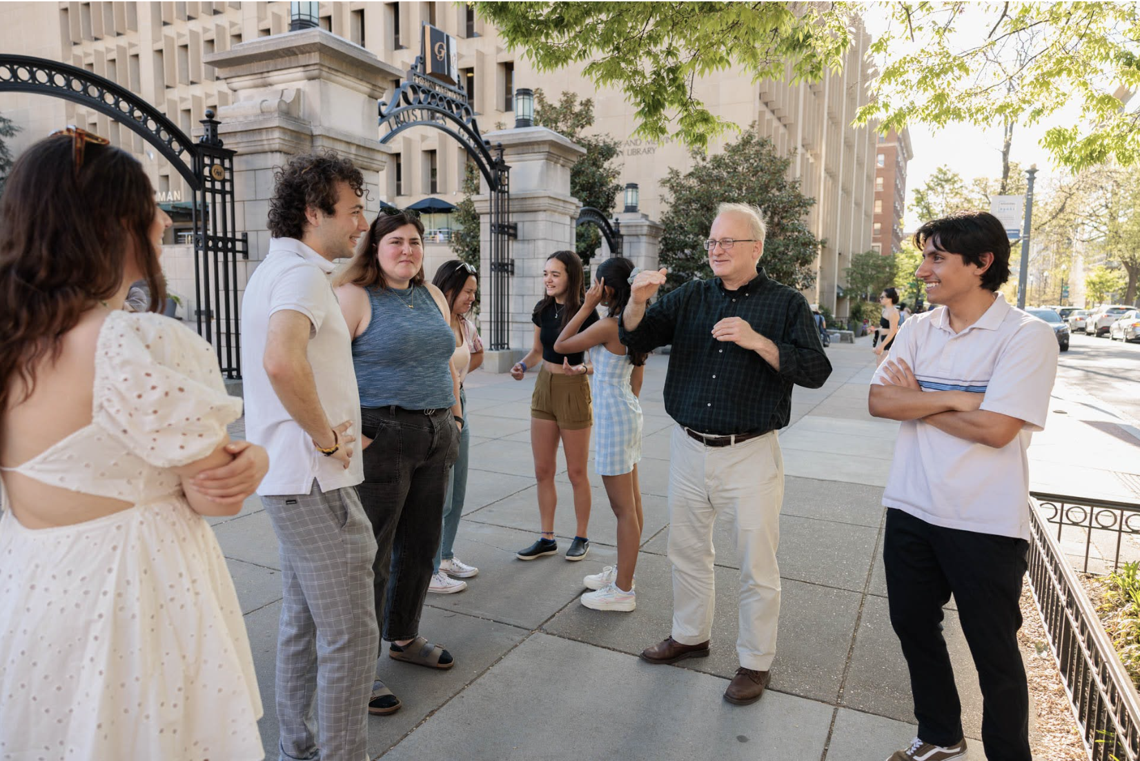 Professor Bob Orttung speaks with members of the fellowship program outside of Professor's Gate on the George Washington University campus.