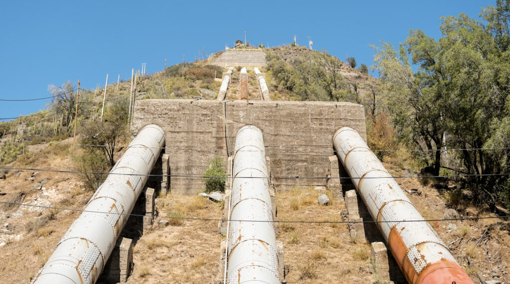 Hydroelectric infrastructure, leading from a station of the Los Maitenes hydroelectric plant, reaches up to a peak along the Rio Maipo valley.
