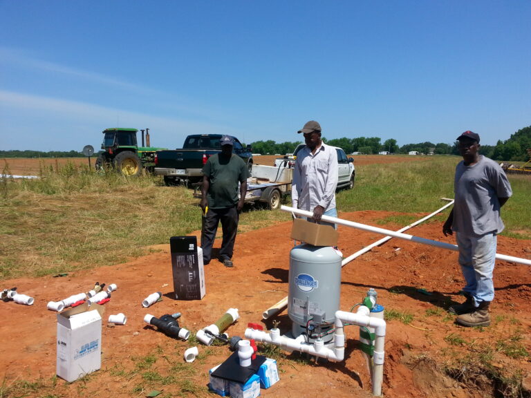 Team members working on an irrigation system to establish sustainable groundwater wells for small farmers in the Alabama Black Belt. 