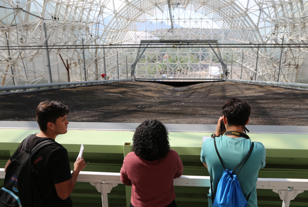 Three students look down an artificial hill inside Biosphere 2. 
