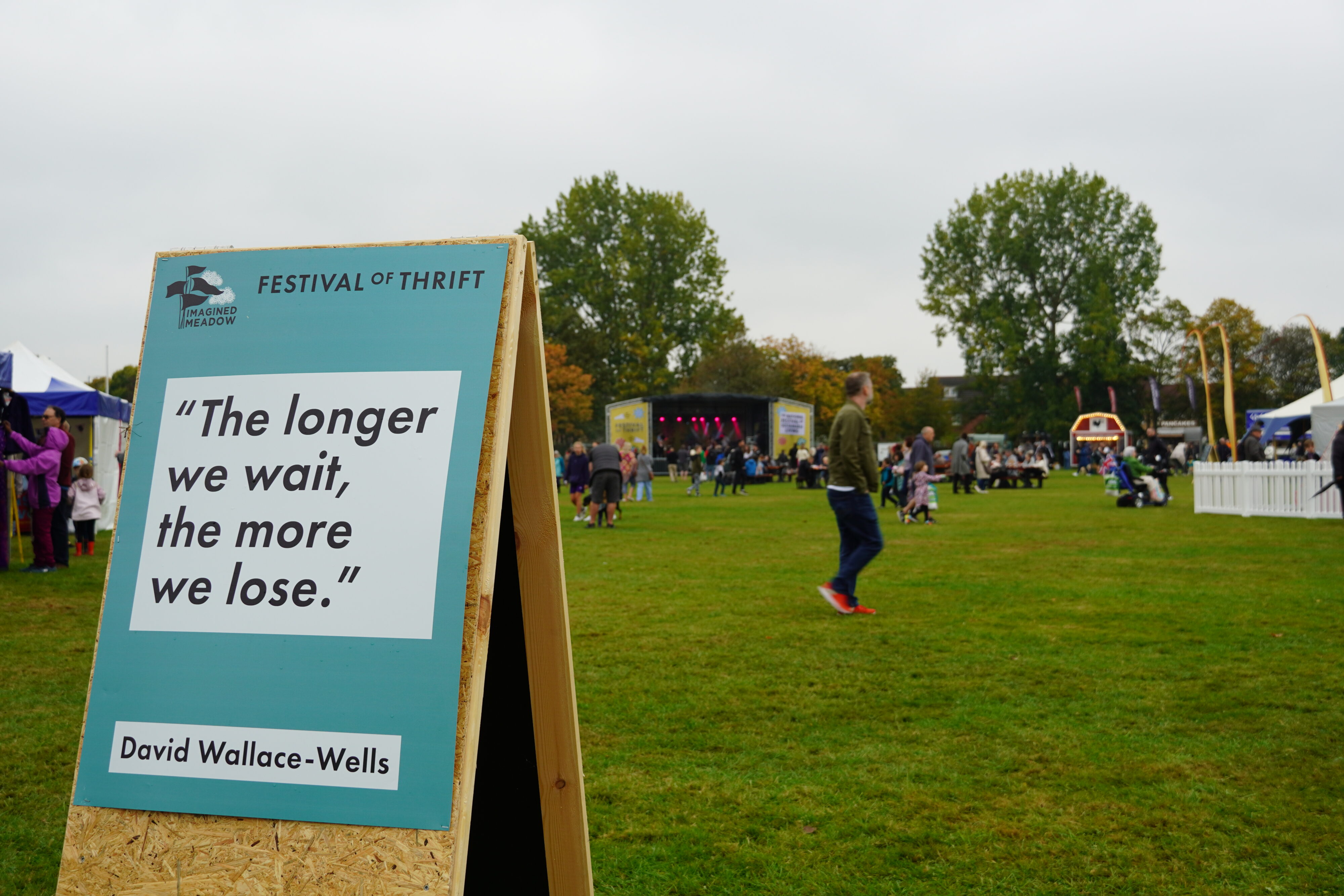 A sign in a lawn at the Festival of Thrift that features a quote reading, "The longer we wait, the more we lose." 