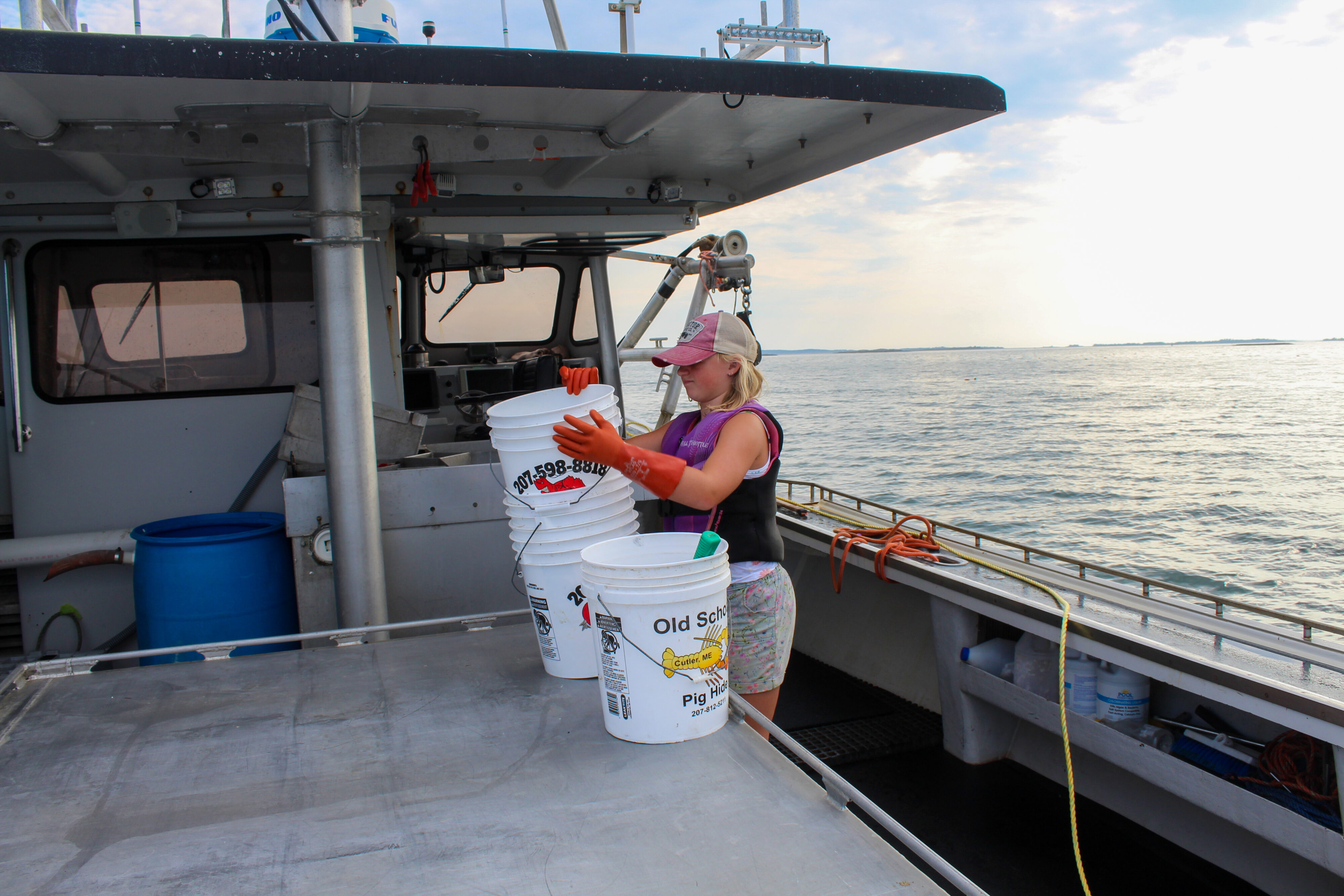 Iris Bly stacks buckets on the boat. 