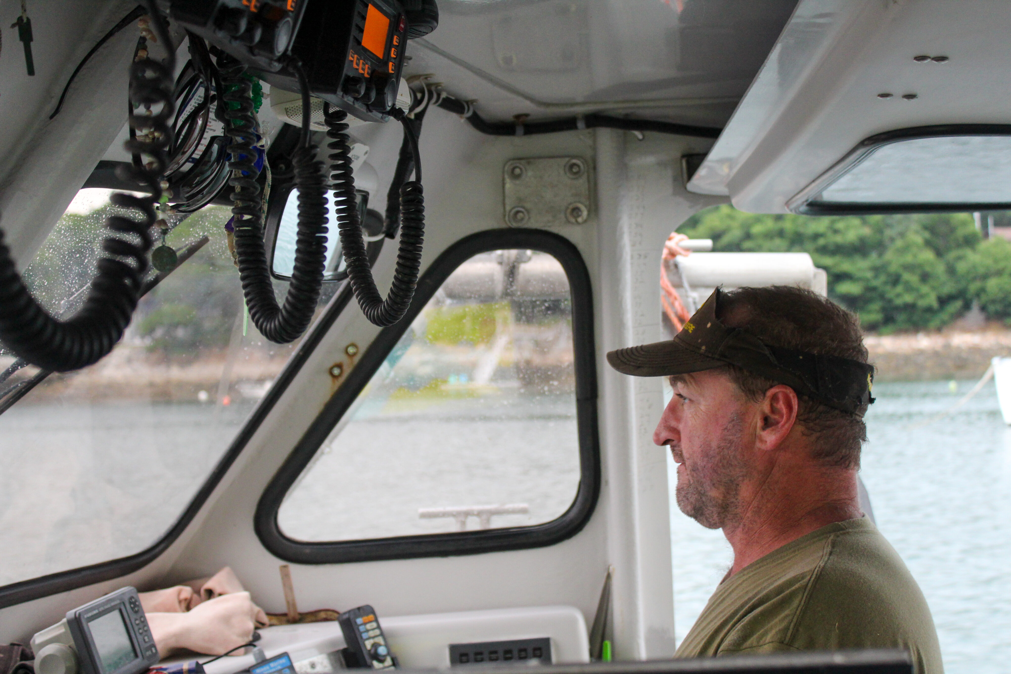 Ivan Bly drives a boat while wearing a sun visor. 