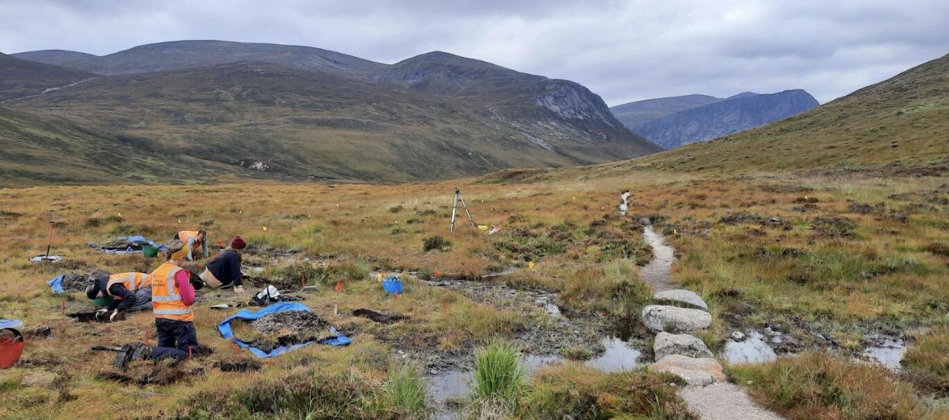 Researchers on a mountainous landscape.