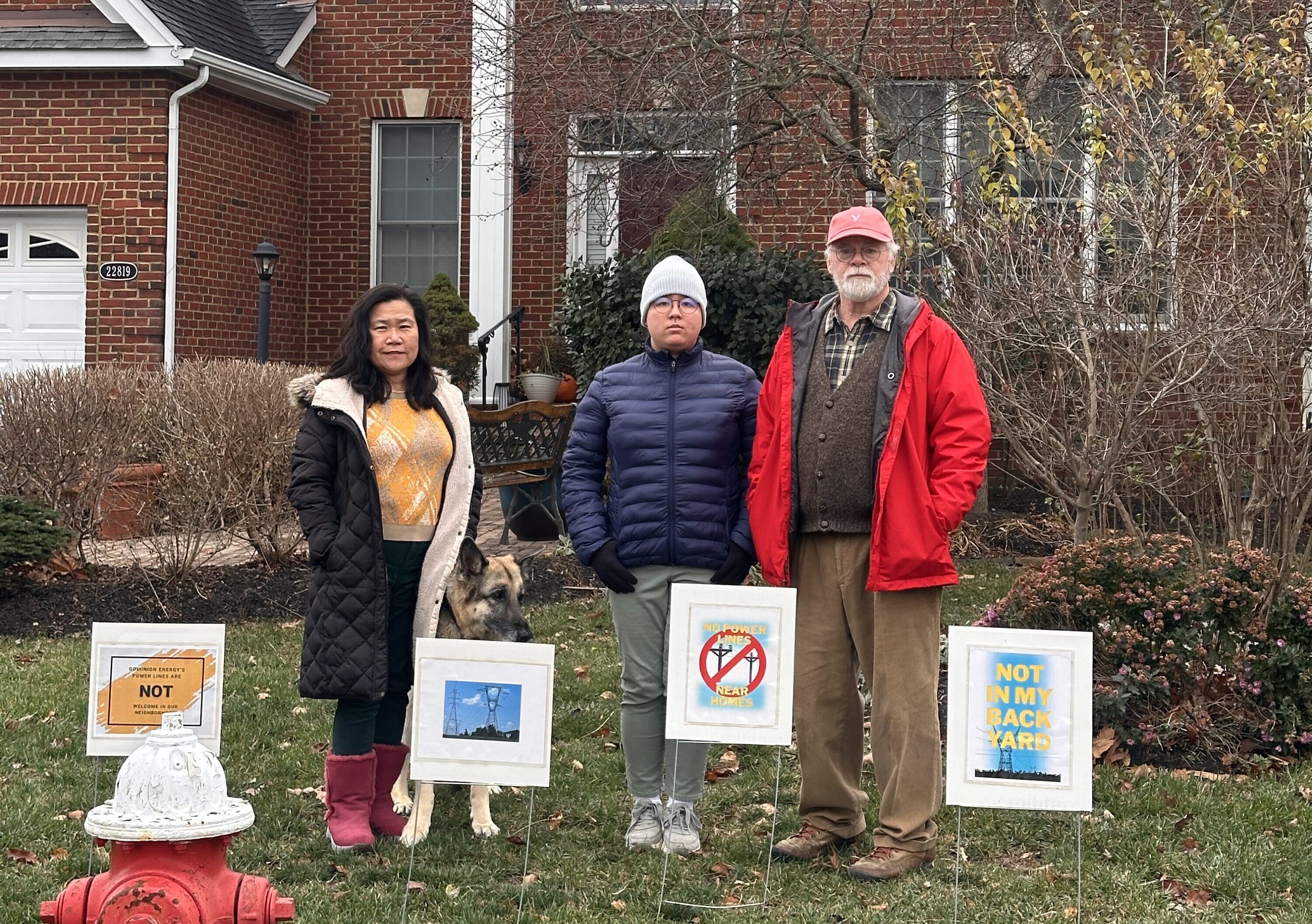 A family with protest signs in front of a house.