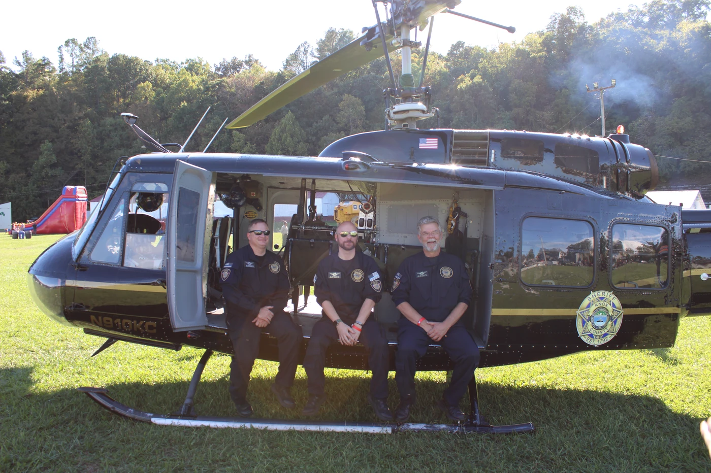 Three police officers sit in a helicopter.