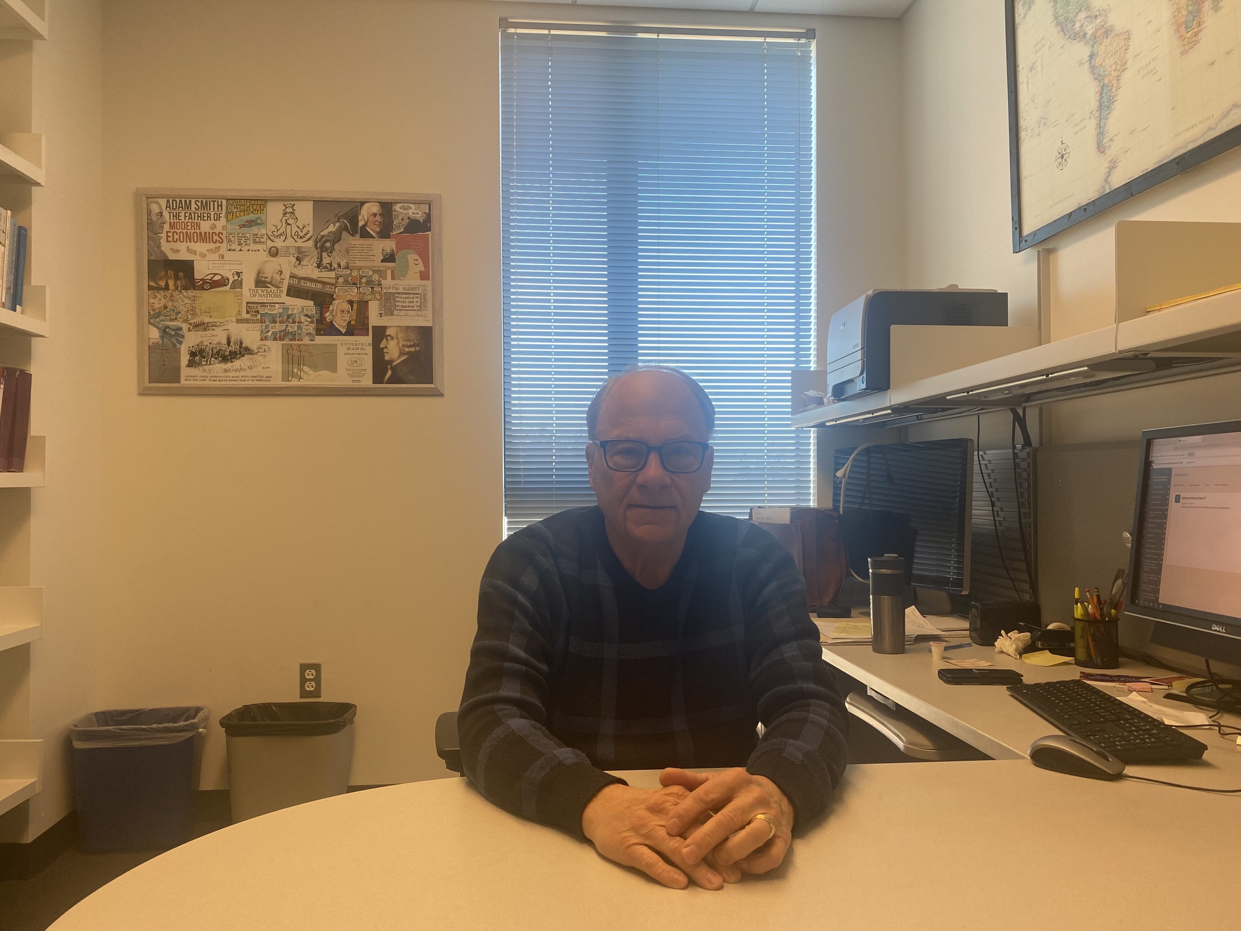 A man sits at a desk.