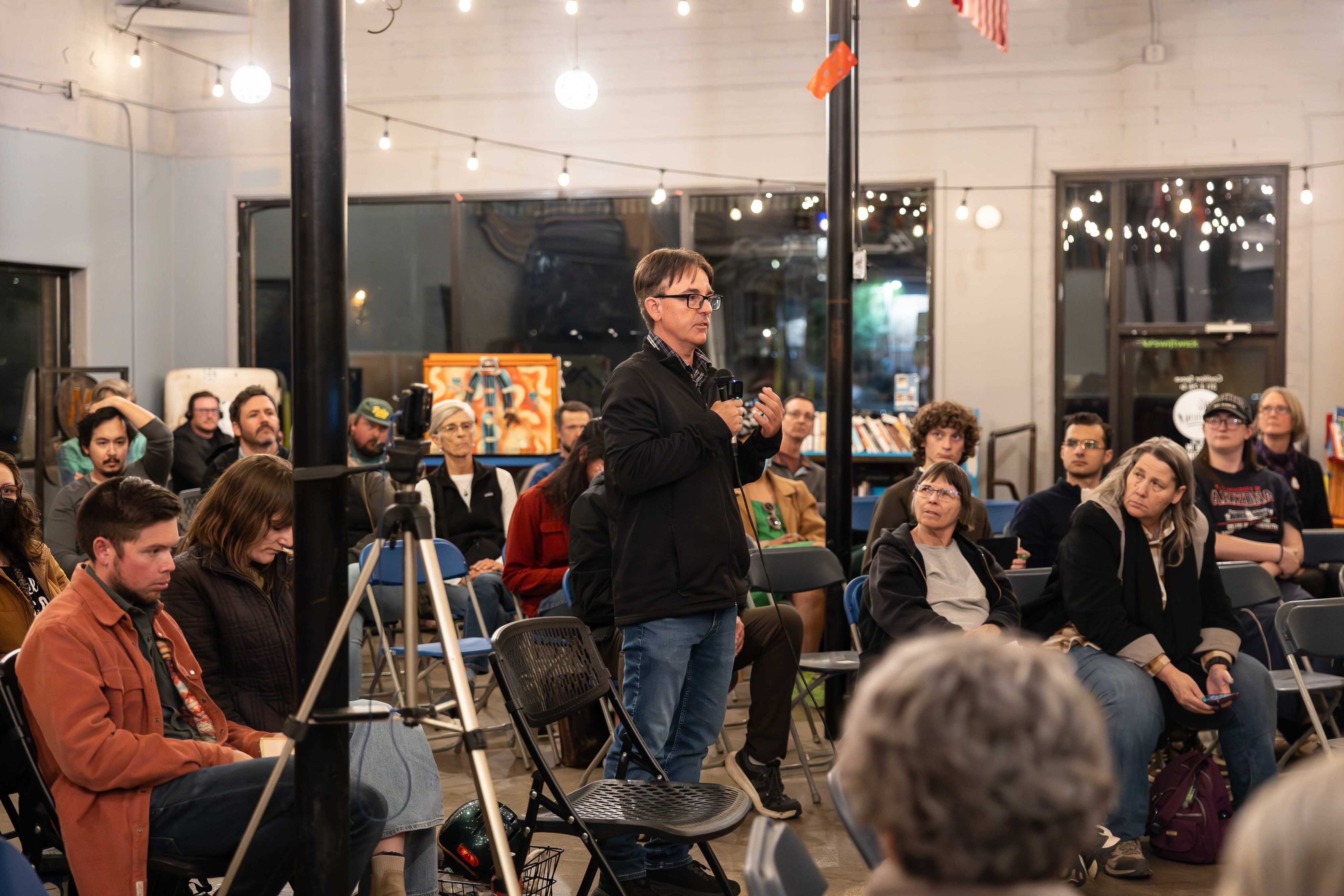 A man stands to ask a question at a forum.