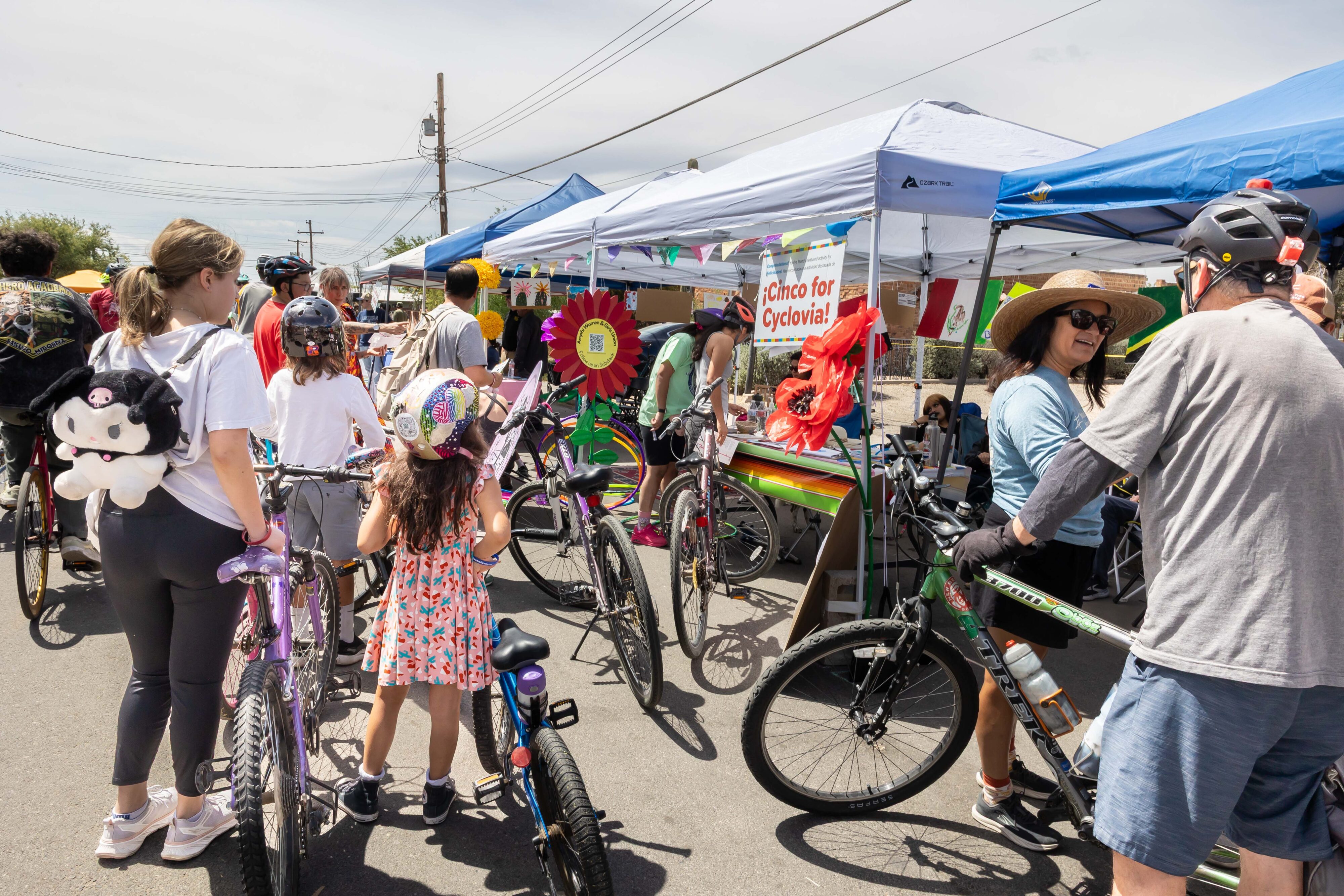 People on bikes at a street festival.