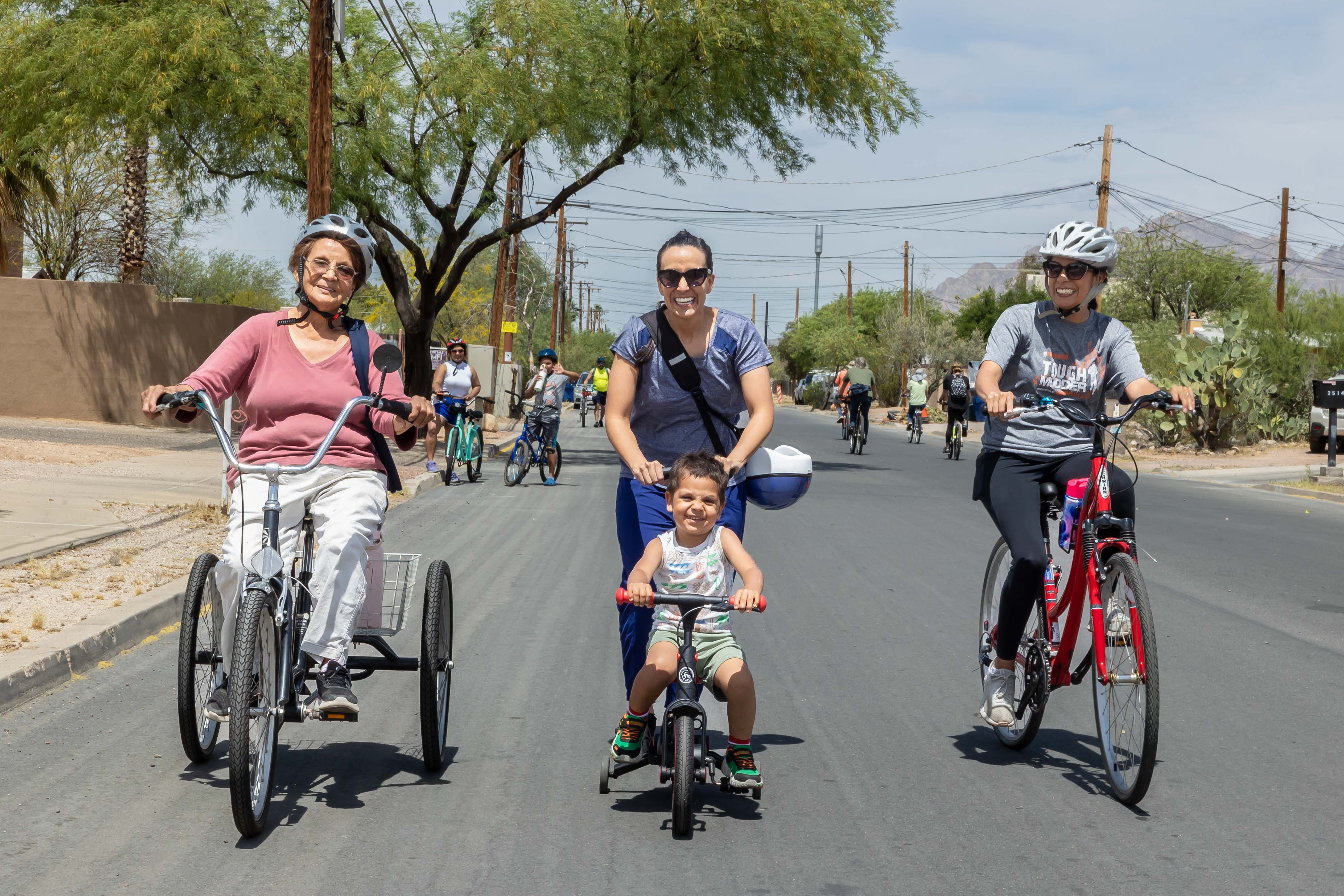 Four people of varying ages biking and smiling.